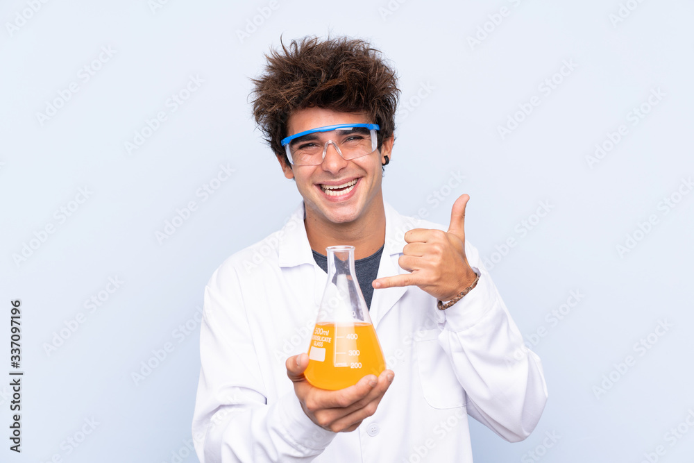 Young scientific man over isolated blue background making phone gesture Young scientific man over isolated blue background making phone gesture