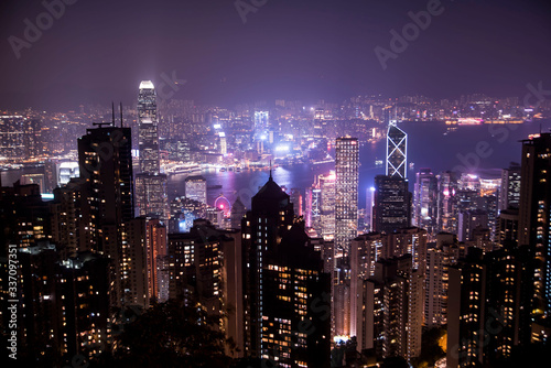 hong kong city skyline at night with glowing buildings © Zach
