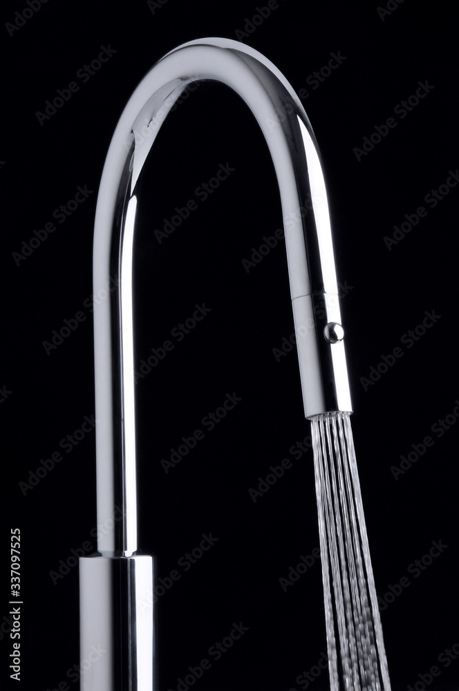 Modern water tap with jet on black background Modern water tap with jet on black background