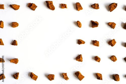 chaga mushroom. broken pieces of birch tree chaga mushroom for brewing natural medicinal antitumor and antiviral detox tea, isolation on white background. regular pattern. space for text