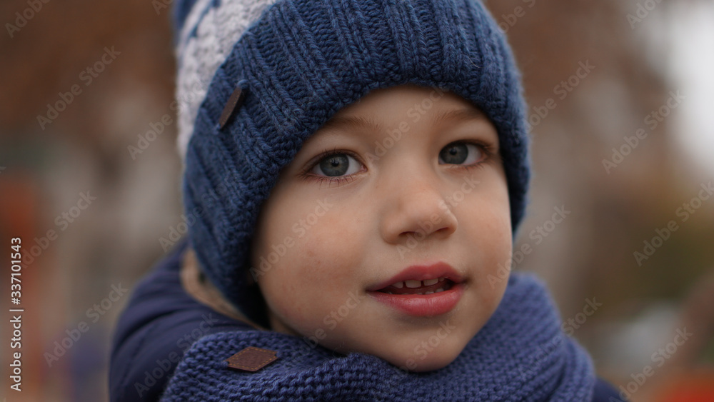 Close-up portrait of little cute boy in a blue knitted hat Close-up portrait of little cute boy in a blue knitted hat