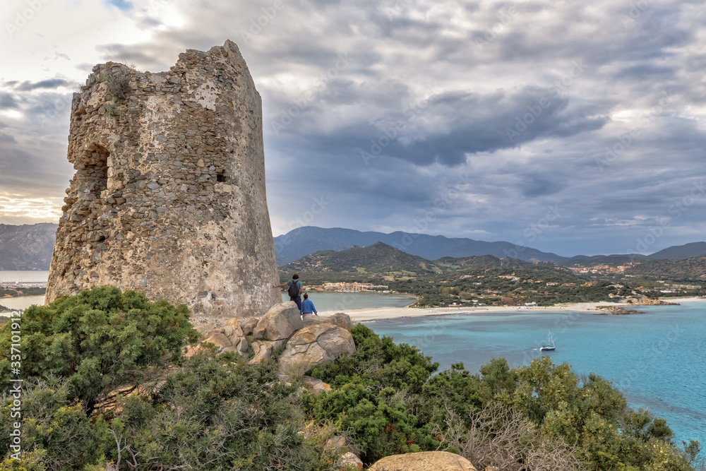Torre di Porto Giunco Tower and Simius Beach near Villasimius, Sardinia, Italy. Backpackers investigating the territory.