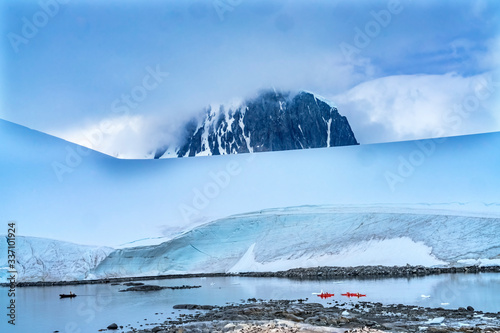 Red Kayaks Iceberg Snow Mountains Blue Glaciers Damoy Point Antarctica photo