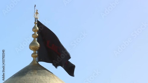 View of the golden dome with a black flag at the mosque Imam Hussain ibn Ali in Karbala Iraq. photo