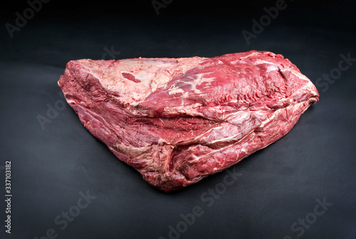 Raw dry aged wagyu beef shoulder clod roast as closeup on black background with copy space