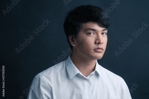 Studio portrait of Asian man on black background