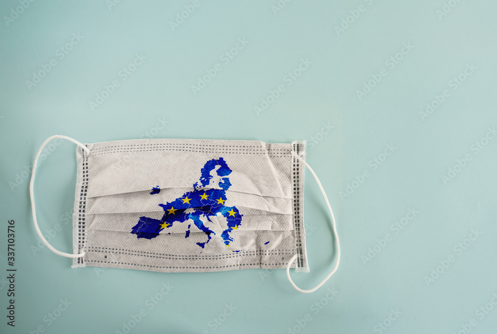 Φωτογραφία White medical mask with coronavirus word and European Union map on it isolated on cyan background