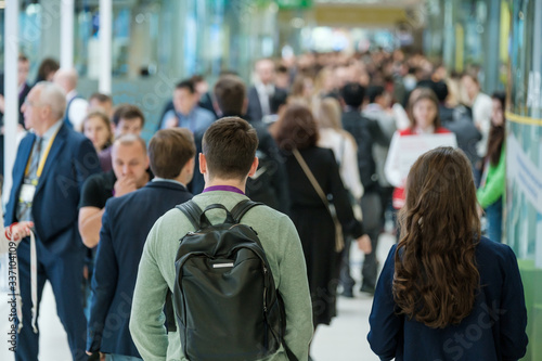 Crowd of people walking indoors, defocused,