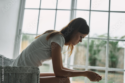 young woman sitting on window sill