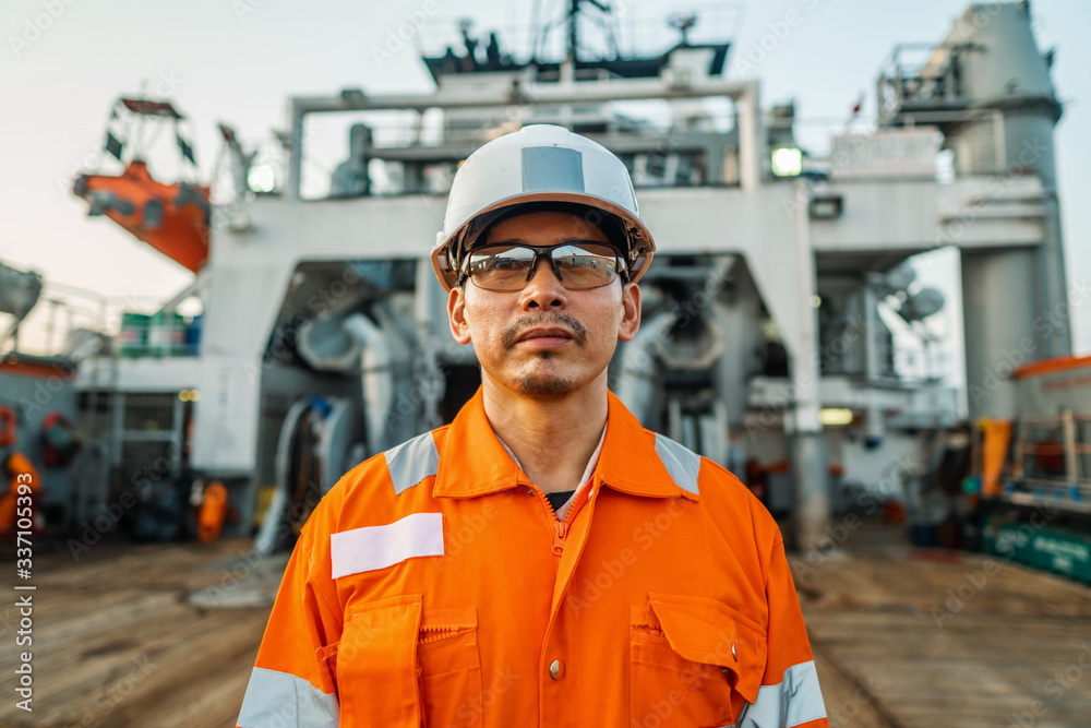 Filipino deck Officer on deck of vessel or ship , wearing PPE personal protective equipment - helmet, coverall, lifejacket, goggles. Safety and work at sea. Filipino deck Officer on deck of vessel or ship , wearing PPE personal protective equipment - helmet, coverall, lifejacket, goggles. Safety and work at sea.