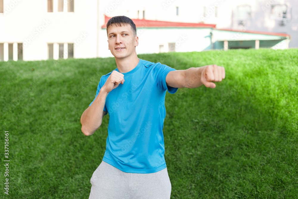 sporty cheerful man trains a shadow fight in a city Park. Concept of fitness, boxing and self-defense sporty cheerful man trains a shadow fight in a city Park. Concept of fitness, boxing and self-defense