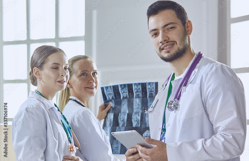 Team of doctors watching x-ray image in a hospital Team of doctors watching x-ray image in a hospital