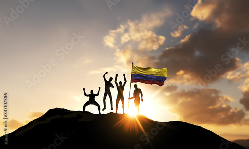 A group of people celebrate on a mountain top with Colombia flag. 3D Render