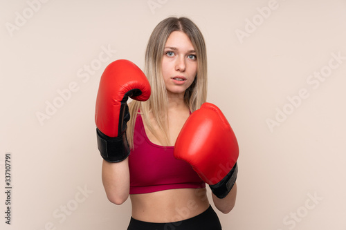 Young sport blonde woman over isolated background with boxing gloves