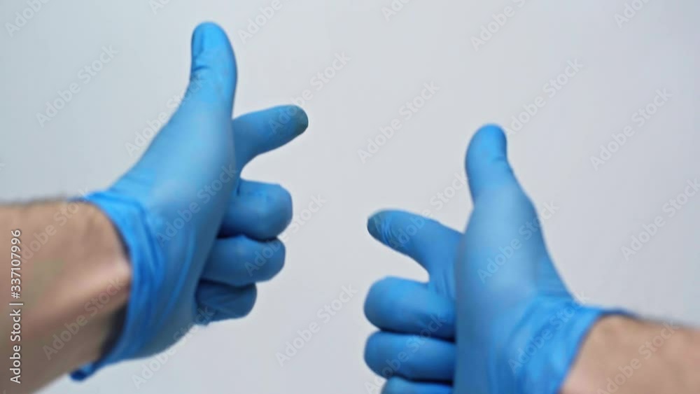 Male hands in blue medical gloves fighting the coronavirus during quarantine. Isolated on a gray background in the studio. Coronavirus concept. Stay at home. Male hands in blue medical gloves fighting the coronavirus during quarantine. Isolated on a gray background in the studio. Coronavirus concept. Stay at home.