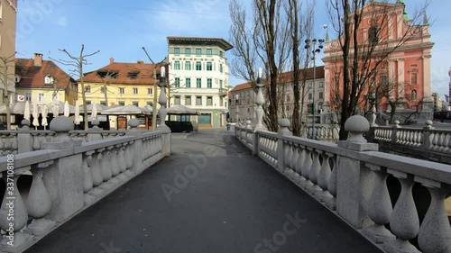Coronavirus COVID 19 quarantine, empty main square and Triple Bridge on workday. Ljubljana city under pandemic lockdown restrictions. Forward dolly moving, walking, wide shot