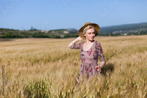 Beautiful fashionable blonde woman in a field of wheat