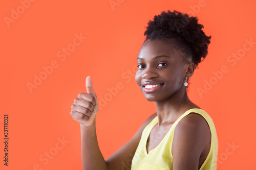 beautiful young african woman on red background with hand gesture