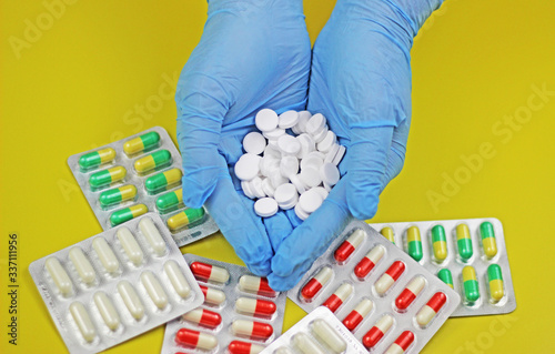 a pile of white pill tablet medicine or supplement in women hands