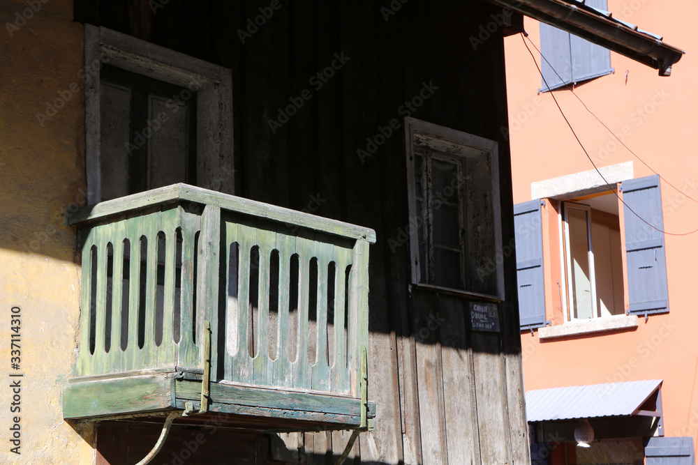Balcon en bois vert sur la façade d'une habitation jaune et en bois. Saint-Gervais-les-Bains. Haute-Savoie. France.