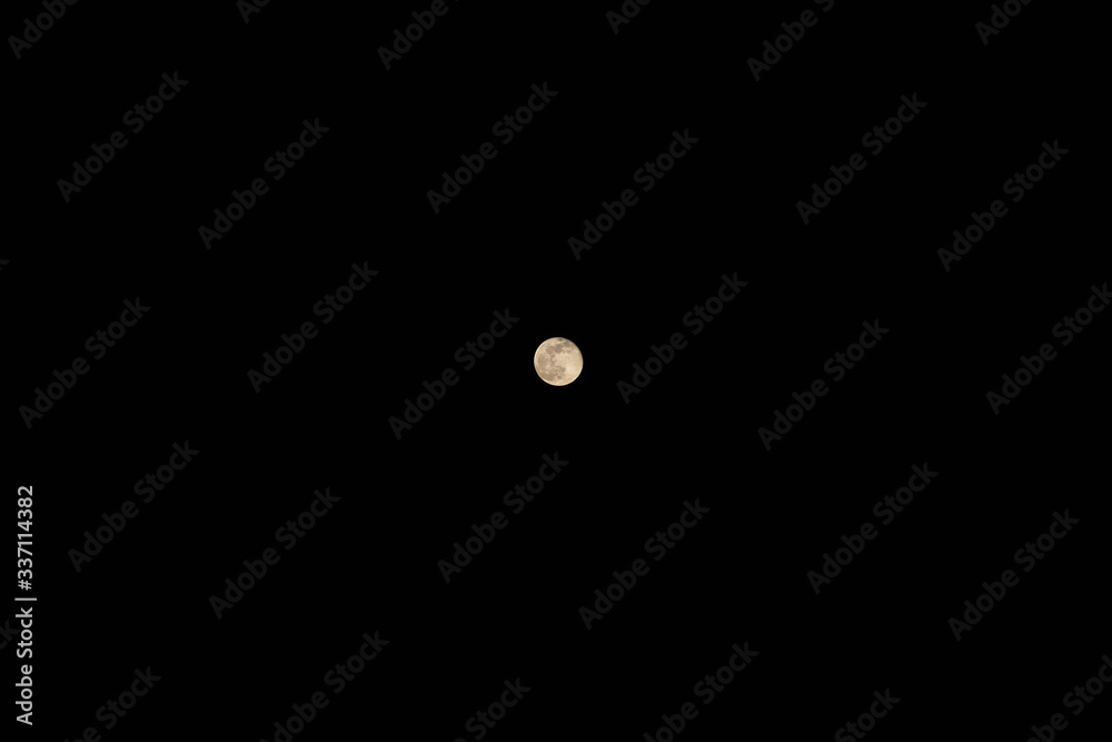 Beautiful view of small full moon in cloudless sky at darkest night. Background, copy space. Idea concept Beautiful view of small full moon in cloudless sky at darkest night. Background, copy space. Idea concept