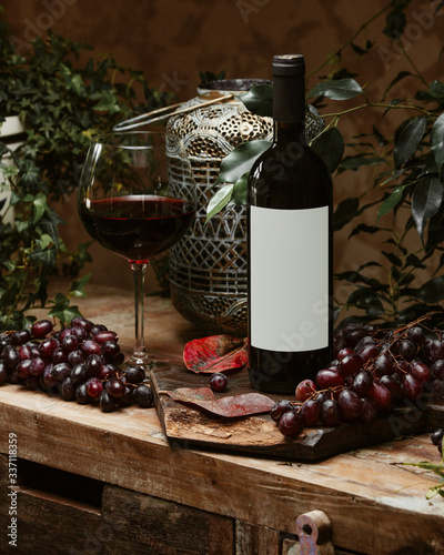 a bottle of red wine and a glass of red wine in rustic style
