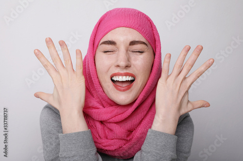 Close-up portrait of a muslim woman wearing a head scarf and smiling. Isolated.