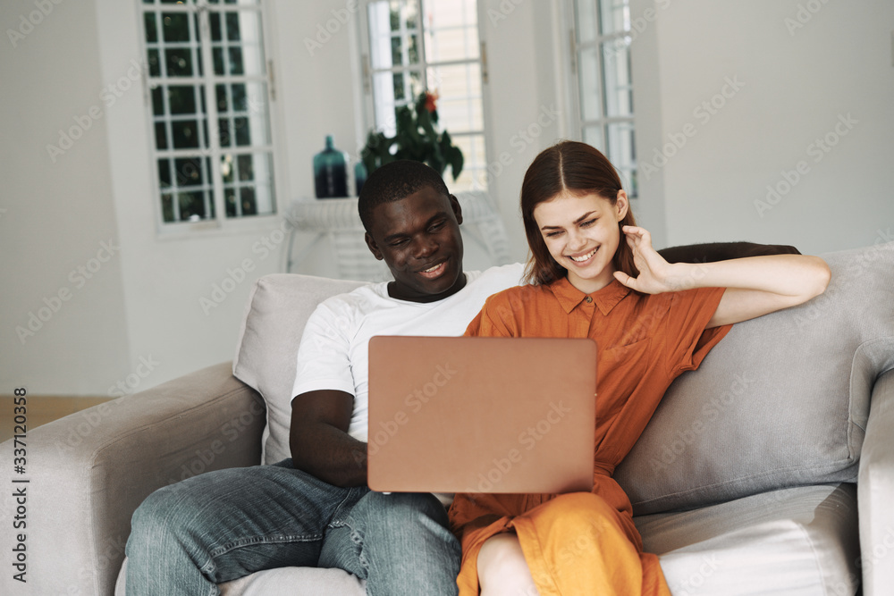 young couple sitting on sofa with laptop young couple sitting on sofa with laptop