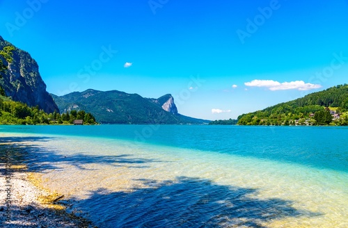 Beautiful View on Mondsee (Moon lake, Moonlake) im Salzkammergut nearby Oberburgau, Schafling, St Gilgen. Salzburg, Austria. Blue sky, water, alps Mountains