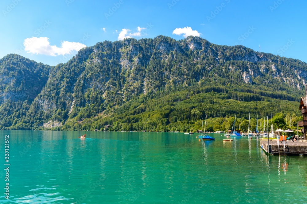 Beautiful view on Attersee lake im Salzkammergut, alps mountain, boat, sailboat in by Unterach. Upper Austria, nearby Salzburg.