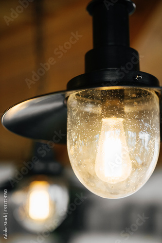 Loft-style luminaires in the interior of a modern cafe. Photo with blurred background.