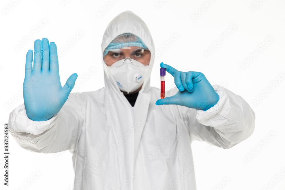 Portrait of a paramedic from a corona patient protective clothing giving a STOP gesture using his hands isolated on gray background. Portrait of a paramedic from a corona patient protective clothing giving a STOP gesture using his hands isolated on gray background.