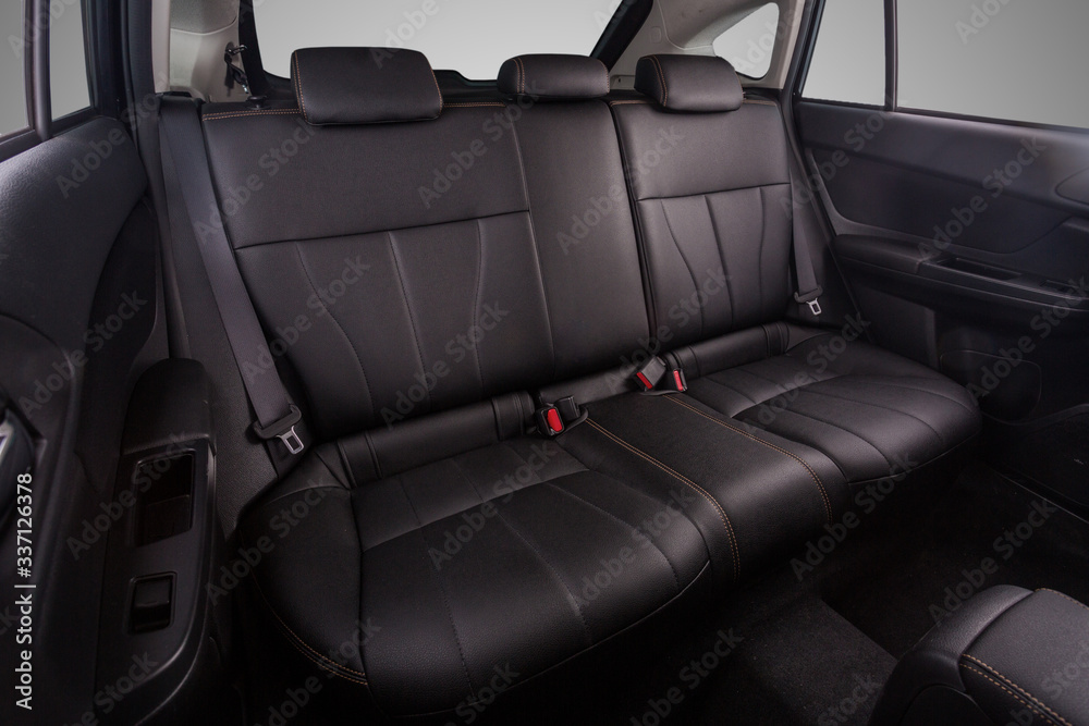 Naklejka premium the interior of the car is covered with handmade genuine leather. back row of car seats. general view. Car doors are visible