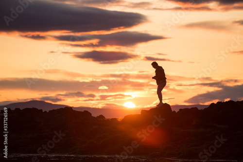 silhouette of a man on a rock at sunset, iceland