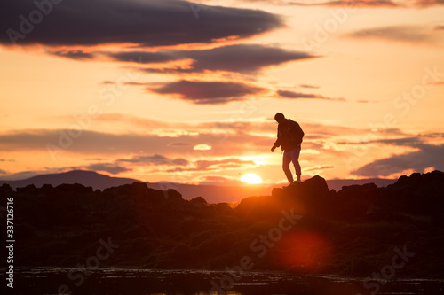 silhouette of a man on a rock at sunset, iceland