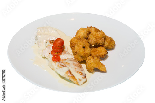 A dish of Turkey stewed in cream sauce and chicken nuggets fried in batter on a white plate. on white background