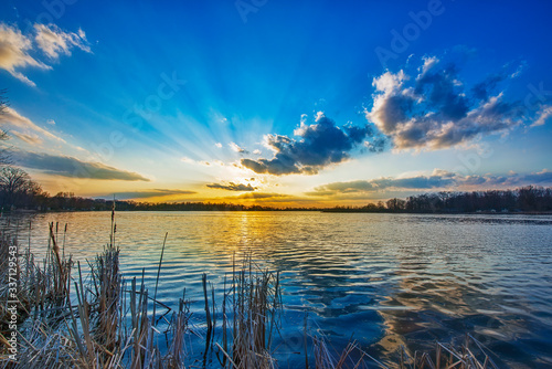 sunrise over the lake with sun on the horizon and sunbeams