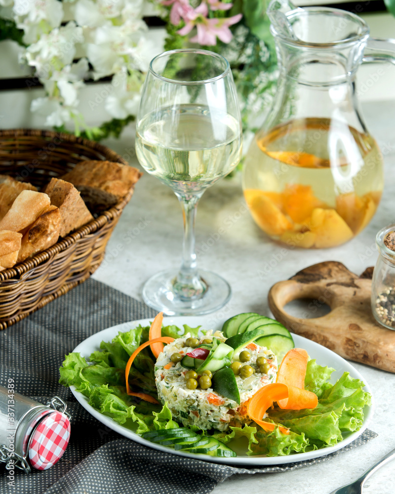 a serving of olivie salad garnished with cucumber decor a serving of olivie salad garnished with cucumber decor