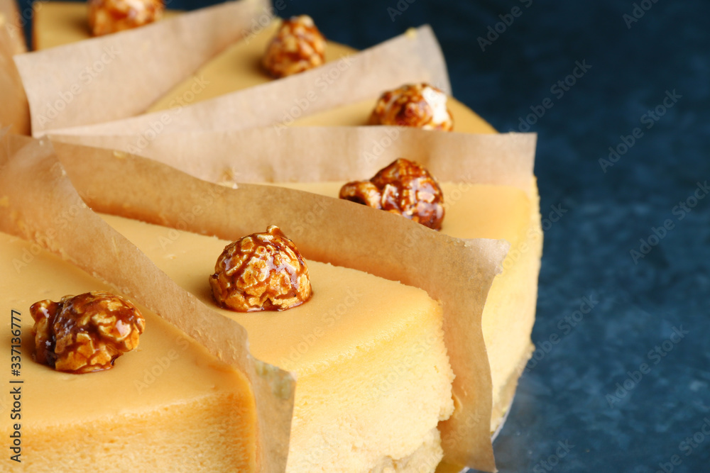 caramel cheesecake with popcorn and salted caramel sauce on blue marble background. portioned dessert decoreted popcorn