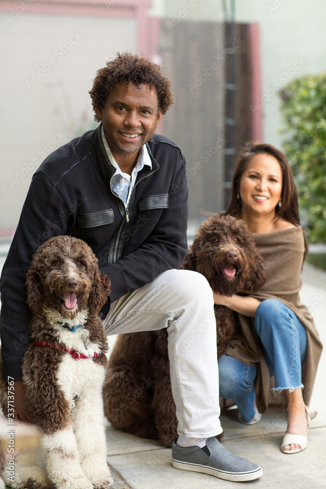 Couple laughing and playing with their dog. Couple laughing and playing with their dog.