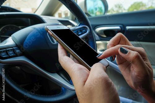 Close up of Woman Hand Sitting Inside Car Typing Text Message On Mobile Phone