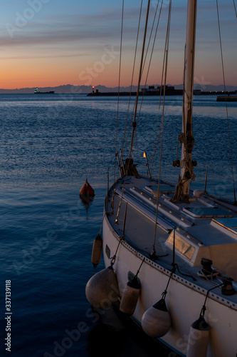 Sailboat in the Trieste harbor at sunset.