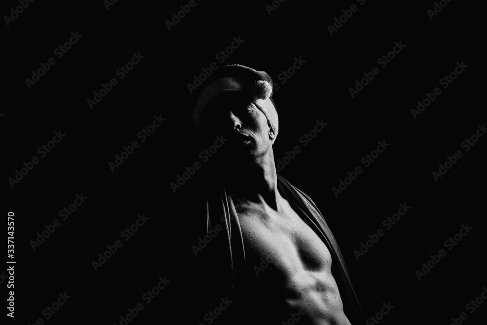 The pumped up body of a man. Black and white background. Sport. Clothing. Body. Beauty and fashion.