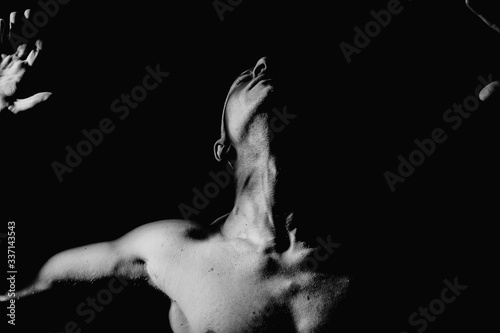The pumped up body of a man. Black and white background. Sport. Clothing. Body. Beauty and fashion.