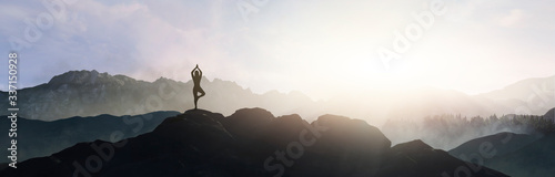 woman doing yoga on top of the mountain photo