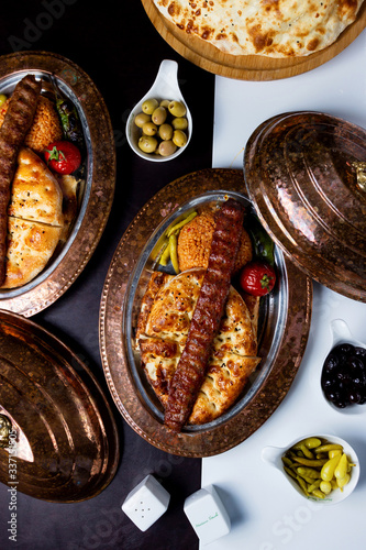 Photography top view of adana kebab served on tandoor bread and bulgur