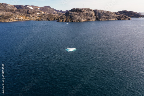 A lone Iceberg sits in an open sea.  photo