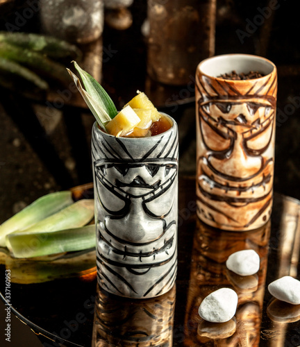 two cups of cocktail in aztec-style mugs