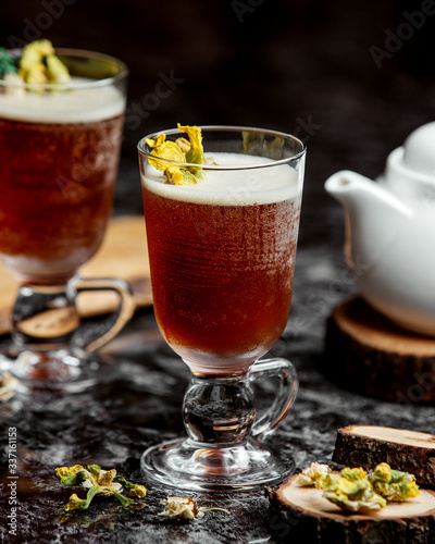 two glasses of cold cocktail garnished with dried flowers