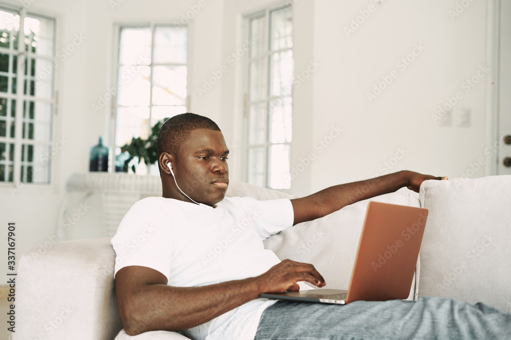 man sitting on sofa with laptop computer man sitting on sofa with laptop computer